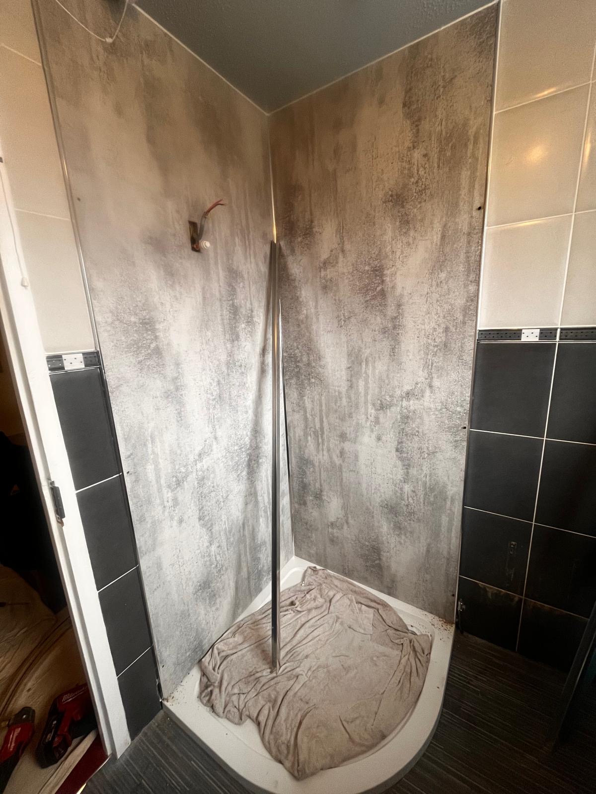 Shower enclosure wall panels being installed