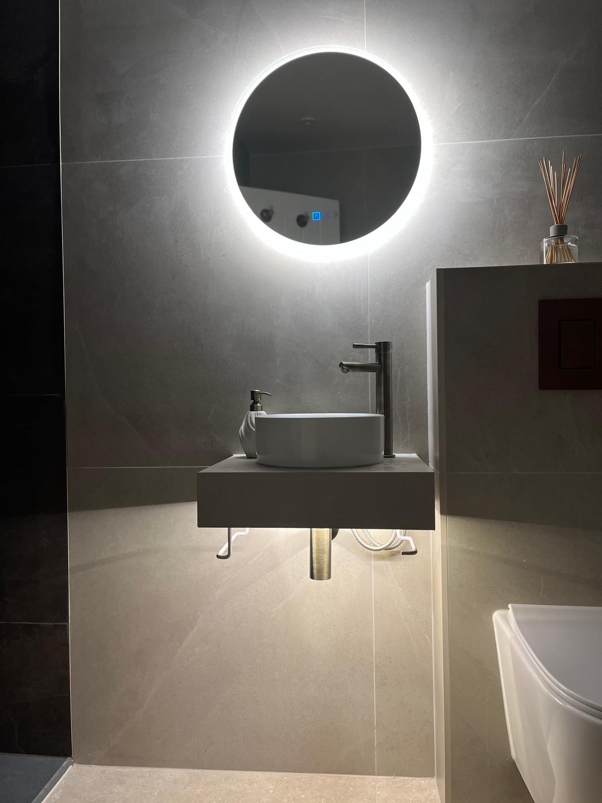 Modern wall-hung basin and illuminated mirror